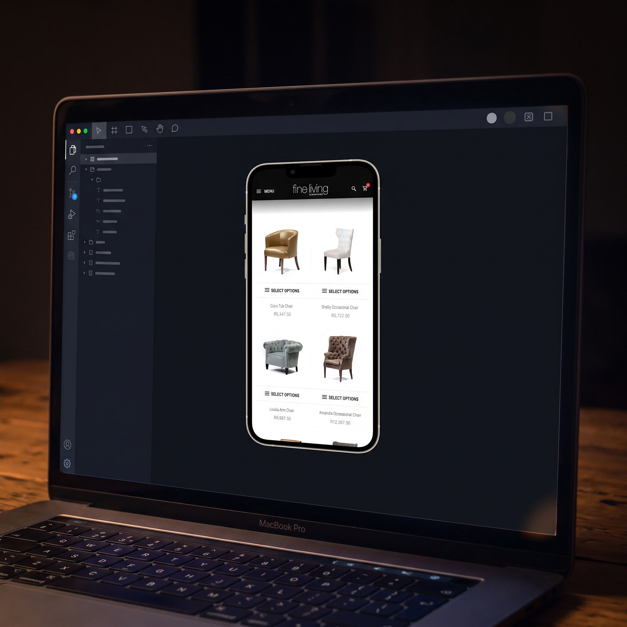 A MacBook Pro on the timber desk at night, a dark design tool filling the screen with the Fine Living mobile store running bright inside a phone preview.